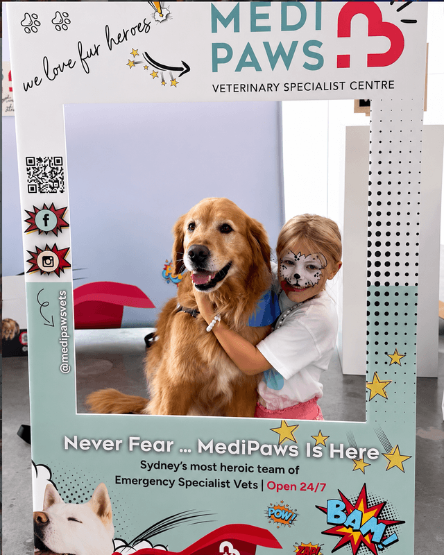 Kid with face paint hugging a golden retriever